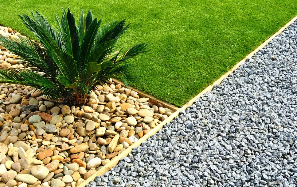 Photo of landscaping with grass, pebbles, and gravel, illustrating outdoor design elements.